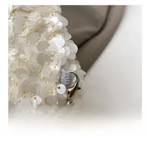 Detail showing the shiny white sequins and sturdy silver metal hook of this trendy bag