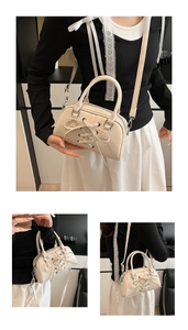 Detail view of cream white Boston bag with elegant bow tie decoration and silver hardware