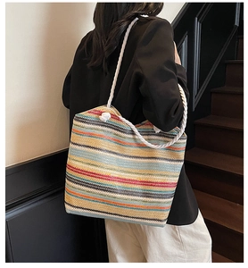 Détail d'un sac cabas tissé à rayures colorées avec bandoulières en corde de coton