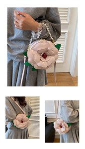 Macro detail of 3D pink camellia flower bag with pearl handle and green leaf accent