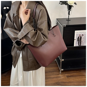 Detail of burgundy leather tote bag with elegant metal chain shoulder strap for women