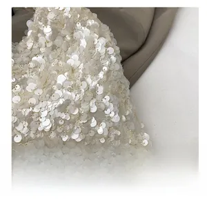 Close-up detail of dense shimmering pearlescent sequins on a trendy fashion handbag