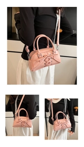 Detail of pink PU leather handbag with lace-up decor and adjustable strap on a model