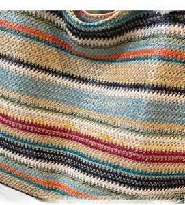 Close-up of multicolored striped woven texture on a handmade straw tote bag surface