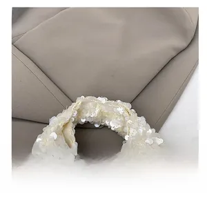 Detailed close-up of the comfortable pearl sequin handle on a stylish handbag