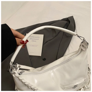 Détail du sac cabas en similicuir blanc brillant avec sangle tissée et fermeture éclair argentée