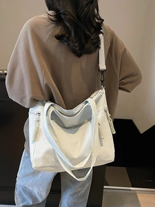 Large white nylon tote bag with wide shoulder strap shown on model for daily commute
