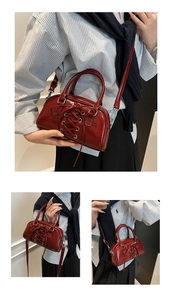 Detail of dark red glossy patent leather shoulder bag with lace-up style details