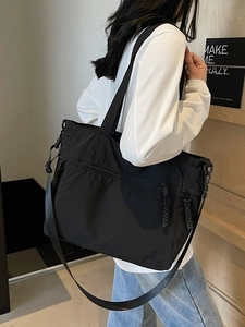 Black large capacity nylon tote bag with wide shoulder strap and woven zipper puller