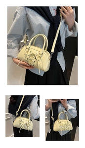 Close-up of cream patent leather crossbody bag with lace-up details and silver hardware