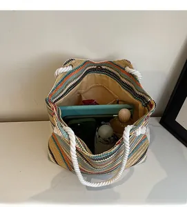 Macro view of a colorful striped straw tote bag showing spacious interior with pockets
