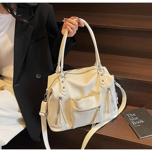Detail of cream large tote bag with lychee grain texture and multiple zip pockets