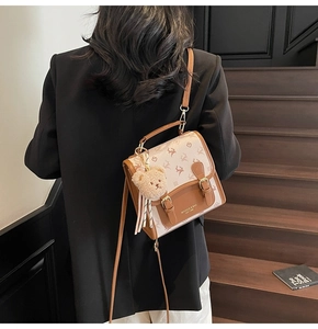 Detail of deer print pattern and brown leather buckle on a stylish mini backpack