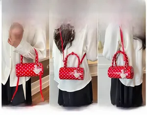 Sac cylindre rouge à pois avec breloque cœur et multiples options de portage à l'épaule