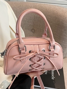 Pink patent leather crossbody bag with silver eyelets and trendy lace-up design
