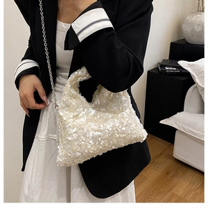 Detail of white sequin handbag with silver chain strap paired with a chic outfit