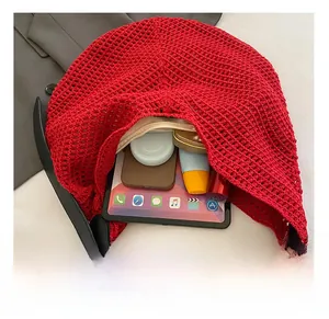 Detail of red hollow crochet tote bag with large capacity and inner zipper pocket