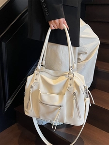 Large white faux leather tote bag with multi-zipper pockets and shoulder strap