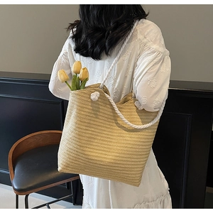 Gros plan d'un grand sac cabas en paille beige avec poignées en corde et décor tulipes