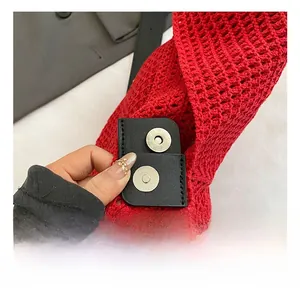 Detail view of the silver magnetic closure on a red woven tote bag with leather padding