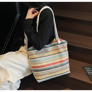 Gros plan d'un sac cabas tissé coloré avec poignées en corde blanche et textures rayées