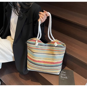 Détail macro du motif tissé multicolore et des anses en corde blanche sur le grand sac