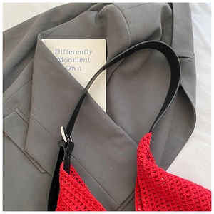 Macro detail of red crochet shoulder bag with mesh knit pattern and black leather strap