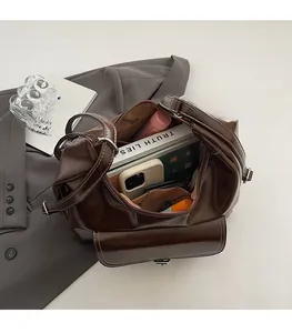 Spacious interior of dark brown oil wax leather shoulder bag with tablet and books