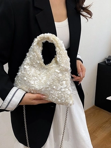 Fashionable beige sequined tote bag with metal chain strap for women shown on model
