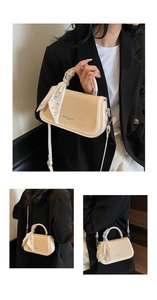 Detail of cream contrast bag with woven texture, silk scarf handle, and crossbody strap