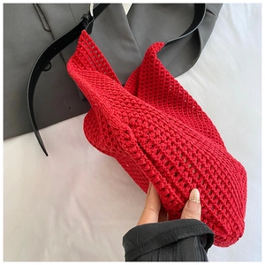 Detail of red crochet knit tote bag showing intricate hollow weave texture and leather strap