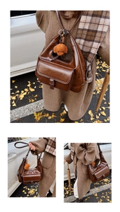 Detail of a brown retro oil wax leather shoulder bag with a teddy bear pendant