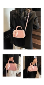 Macro detail of a pink handbag with decorative heart scarf and stylish brand lettering
