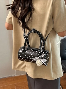 Chic black and white polka dot barrel bag with pearl heart charm and lace bow detail