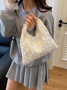 Chic pearl white sequin handbag with chain strap shown in a modern home setting