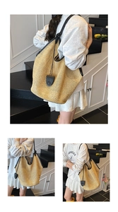 Detail view of woven straw tote bag with black leather trim shown on a model in a minimalist setting