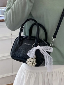 Modische schwarze Bowlingtasche mit weißer Spitzenschleife und Perlenanhänger