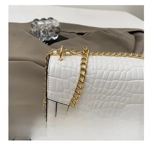 Detailed close-up of white crocodile pattern leather and gold metal chain strap on bag