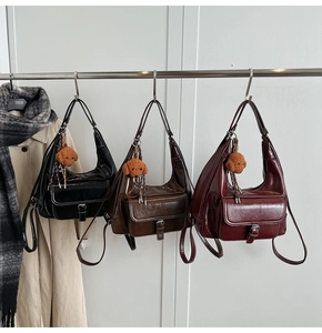 Three oil wax leather shoulder bags in black, brown, and burgundy with teddy bear charms