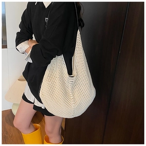 Detailed view of cream woven shoulder bag with large capacity mesh design on female model