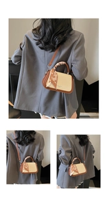 Detail of retro small square bag with woven texture, leather piping and silk scarf handle