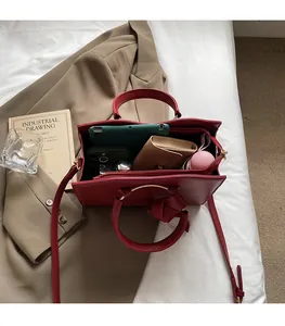 Vue intérieure du sac à main rouge montrant sa grande capacité pour tablette et portefeuille