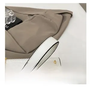 Close-up of white crocodile pattern leather strap and elegant gold metal chain link