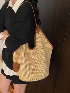 Large woven straw tote bag with brown leather trim for summer beach and vacation