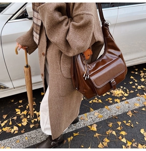 Brown wax leather shoulder bag with buckle pocket and fringe detail in autumn street style