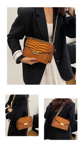 Detailed view of vintage crocodile pattern leather bag with gold chain strap in brown