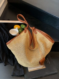 Handwoven straw tote bag with brown leather handles for summer beach vacation style