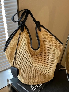 Large capacity woven straw tote bag with black leather trim and heart charm detail