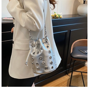Metallic silver bucket bag with eyelet details styled with a white blazer for fashion