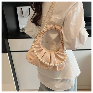 Detail of soft pleated crescent bag with pearl chain handle and elegant ruffles